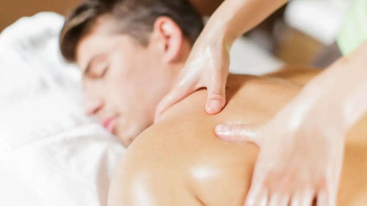Massagem sensual: como fazer em seu parceiro em 8 passos Pessoa fazendo uma massagem sensual nas costas de um homem.