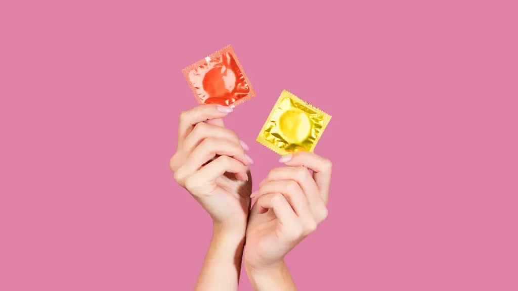 A imagem mostra só as mãos de uma pessoa segurando duas das melhores camisinhas.