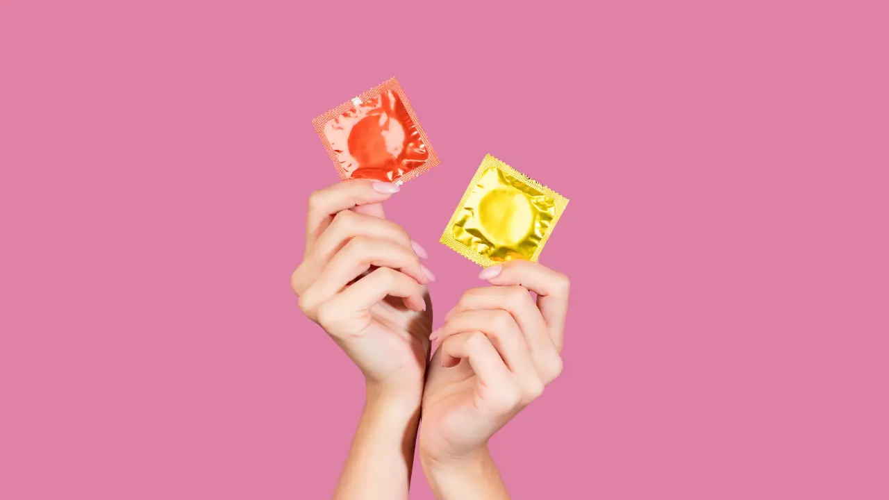 A imagem mostra só as mãos de uma pessoa segurando duas das melhores camisinhas.