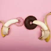 Como fazer dupla penetração? 8 dicas para começar certo Imagem ilustrativa mostrando 2 bananas e 2 roquinhas, remetendo a como fazer dupla penetração.