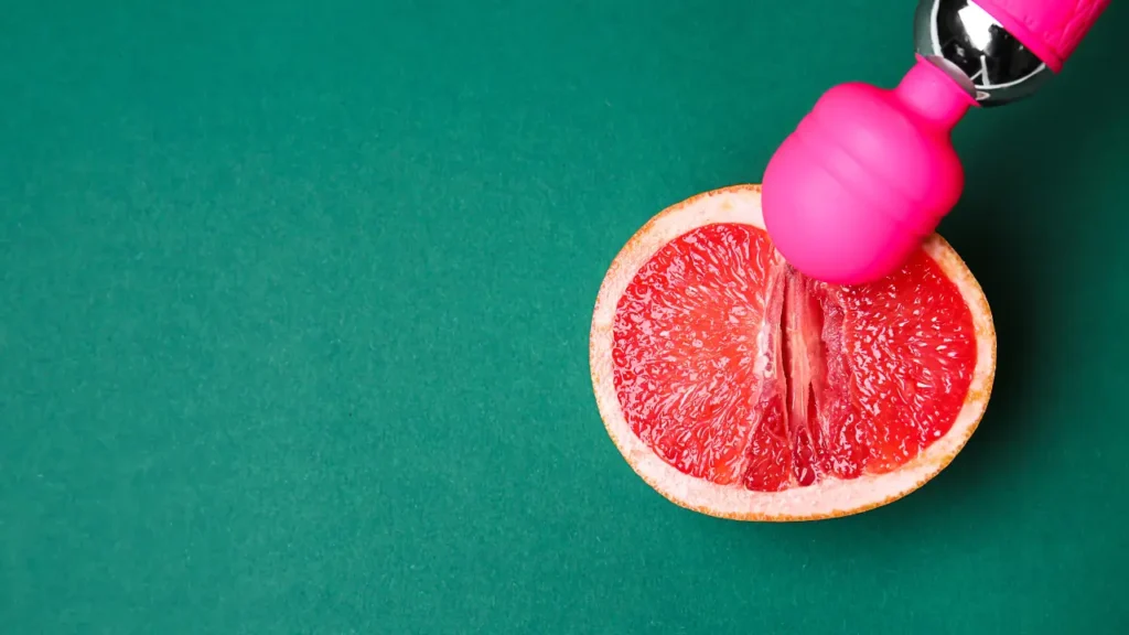 8 melhores vibradores para casal para mais prazer a dois Imagem ilustrativa de um vibrador sob uma laranja partida.
